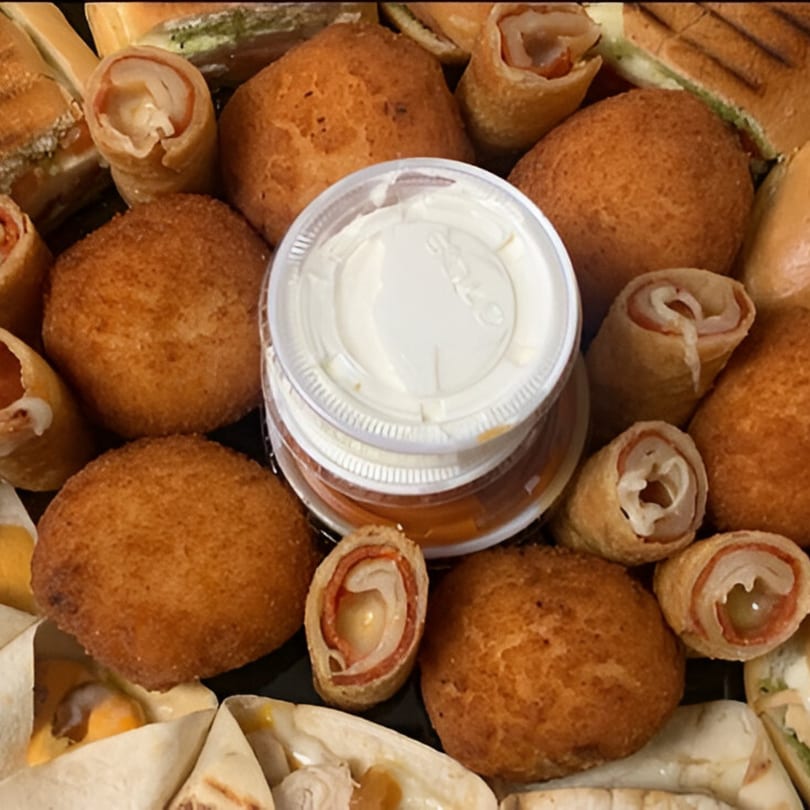 A platter of golden-brown fried appetizers, rolled sandwiches, and dipping sauces from Sandwich Club.